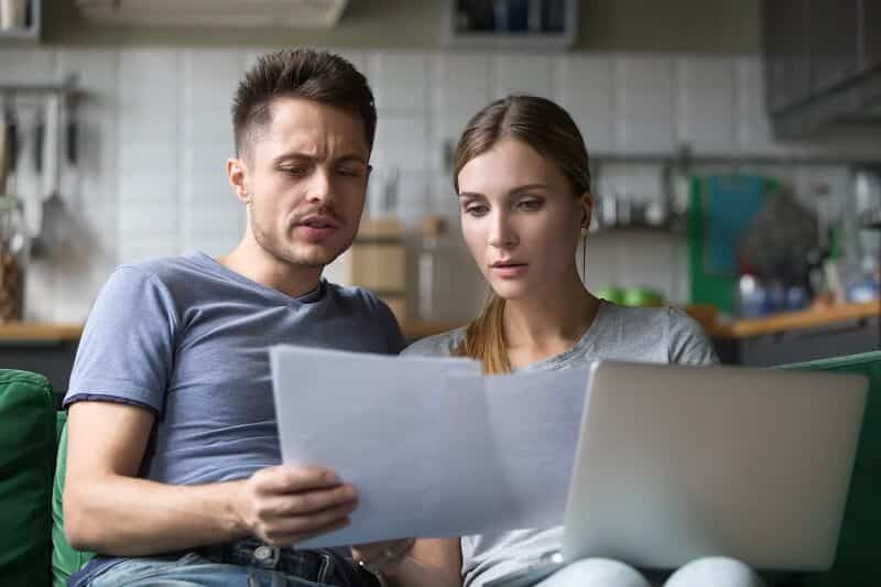 Two young homeowners researching different options to avoid lender-required repairs